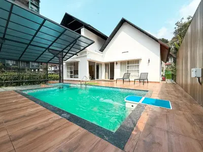 a swimming pool in the backyard of a house at Fog Land Pool Villa by BMT in Vythiri