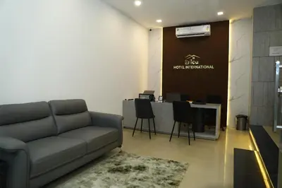 a living room with a couch and a table with chairs at Erica Hotel International in Perintalmanna