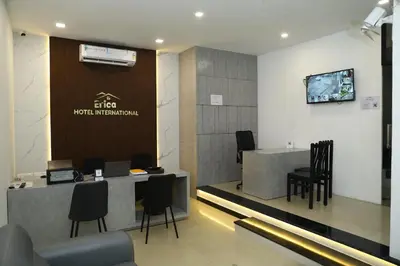 a lobby of a hotel with a reception desk and chairs at Erica Hotel International in Perintalmanna