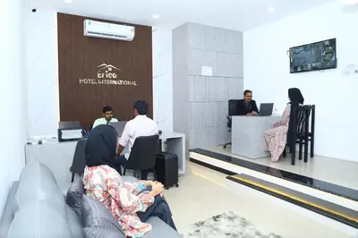 a group of people sitting at a desk in a lobby at Erica Hotel International in Perintalmanna