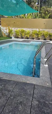 a large swimming pool with a stairway leading into it at Royal Heaven in Ambalavayal