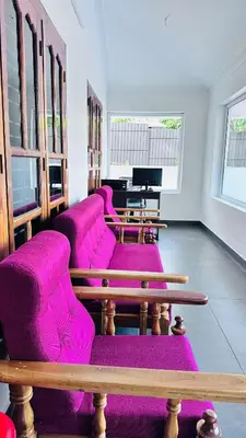 a row of purple chairs in a room with a piano at Royal Heaven in Ambalavayal