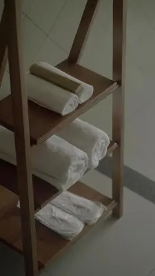 a group of towels on a shelf in a bathroom at Tangerine Tales Boutique Resort By LexStays in Wayanad