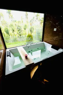 a bathroom with a sink and a large window at Tangerine Tales Boutique Resort By LexStays in Wayanad