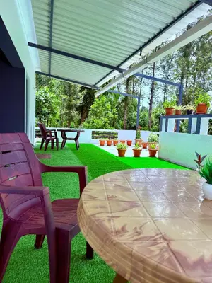 a patio with a table and chairs on the grass at Anya Retreats Nature Homestay in Kushālnagar