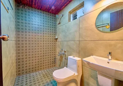 a bathroom with a toilet and a sink and a mirror at Whispering Hills Pine Malhar Pool & Tent Attappadi by VOYE HOMES in Attappādi