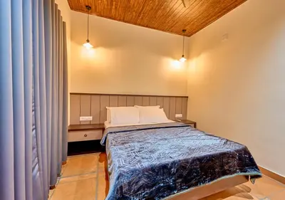 a bedroom with a bed in a room at Whispering Hills Pine Malhar Pool & Tent Attappadi by VOYE HOMES in Attappādi