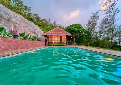 a house with a swimming pool with a gazebo at Whispering Hills Pine Malhar Pool & Tent Attappadi by VOYE HOMES in Attappādi