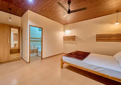 a bedroom with a bed and a bathroom at Whispering Hills Pine Malhar Pool & Tent Attappadi by VOYE HOMES in Attappādi
