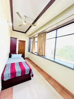 a bedroom with a bed and a large window at Hotel Alsaj in Alwaye