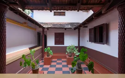 a room with potted plants in a house at SaffronStays Amaya - 5BR 300-year-old Kerala-style heritage villa with spa near Kannur Airport in Irikkūr