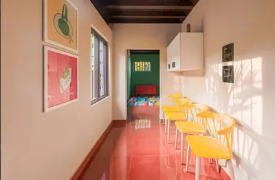 a room with yellow chairs and a green door at SaffronStays Amaya - 5BR 300-year-old Kerala-style heritage villa with spa near Kannur Airport in Irikkūr