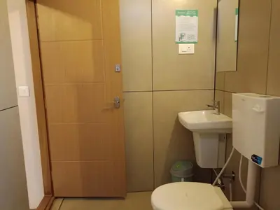 a bathroom with a toilet and a sink at Zostay Urban Retreat Deluxe Rooms & Premium Dorms in Manjeri