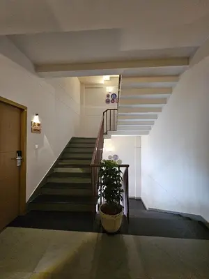 a staircase in a building with a potted plant at Zostay Urban Retreat Deluxe Rooms & Premium Dorms in Manjeri