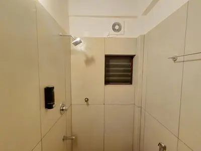 a shower with a glass door in a bathroom at Zostay Urban Retreat Deluxe Rooms & Premium Dorms in Manjeri