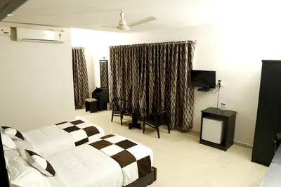 a bedroom with a bed and a television in it at Rydges Inn in Kottakkal