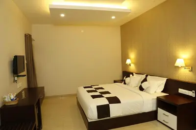 a hotel room with a bed and a television at Rydges Inn in Kottakkal