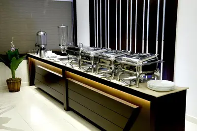 a counter with a bunch of pots and pans at Rydges Inn in Kottakkal
