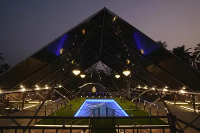 a pyramid shaped building with a swimming pool at night at Parlak in Karuvapadna