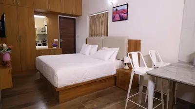 a bedroom with a white bed and a counter at Mira Homestay in Kodaikānāl
