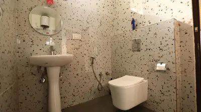 a bathroom with a toilet and a sink and a mirror at Mira Homestay in Kodaikānāl