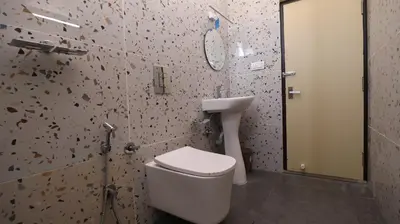 a bathroom with a toilet and a sink at Mira Homestay in Kodaikānāl