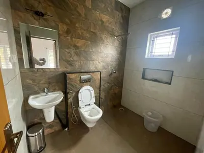 a bathroom with a toilet and a sink at May Flower Cottage in Ooty