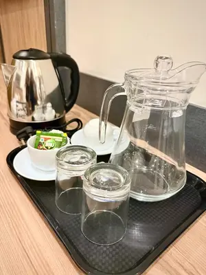 a tray with a tea pot and glasses on a table at Stay Bridge Residency in Kozhikode