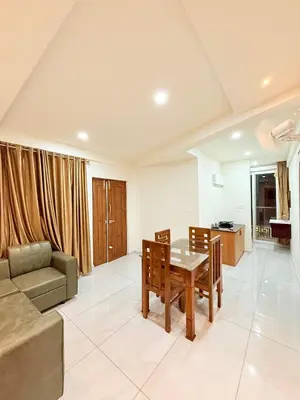 a living room with a table and a couch at Stay Bridge Residency in Kozhikode