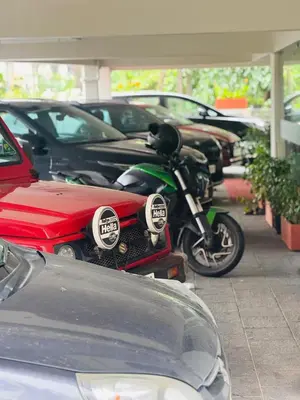 a motorcycle parked in a parking lot with cars at Stay Bridge Residency in Kozhikode