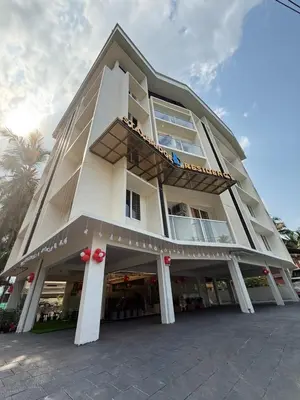 a large white building with a balcony at Stay Bridge Residency in Kozhikode