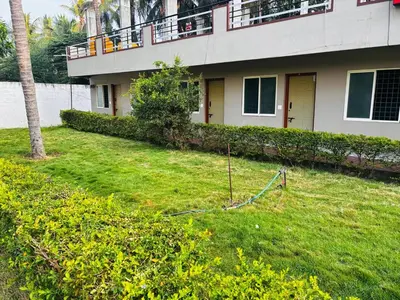 a house with a lawn in front of it at Yash Residency in Mysore