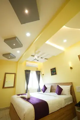a bedroom with two beds and a window at M M Hotel Royal Respite in Coimbatore