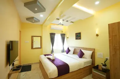 a bedroom with a bed with purple pillows and a window at M M Hotel Royal Respite in Coimbatore