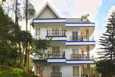 a white house with blue trim at The Heights Munnar in Munnar