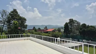 a balcony with a white railing and a view of trees at Mountain Top Holiday Home in Ooty