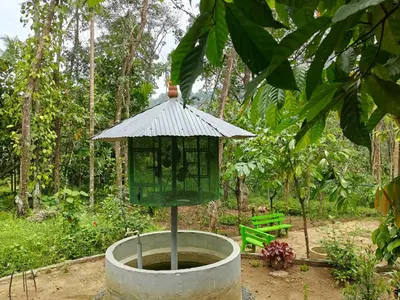 a bird bath with a bird feeder in a garden at Rainy Woods Inn in Neriyamangalam
