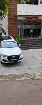 a white car parked in front of a building at Redbell Suites Civil in Kozhikode