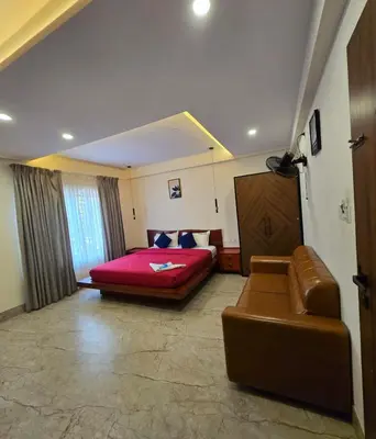 a bedroom with a bed and a couch in it at Redbell Suites Civil in Kozhikode