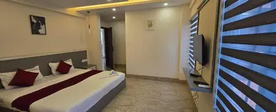 a bedroom with a bed and a flat screen tv at Redbell Suites Civil in Kozhikode