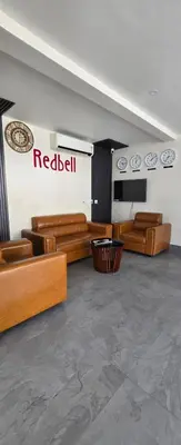 a room with wooden furniture and a redbull sign on the wall at Redbell Suites Civil in Kozhikode