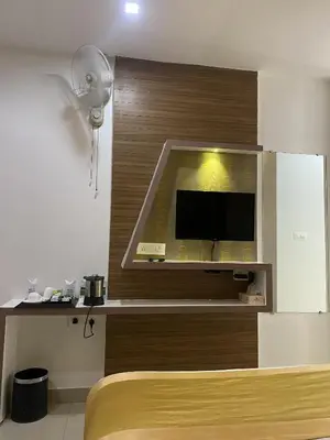 a bedroom with a tv on a wall at Pumpkin Tower in Malappuram