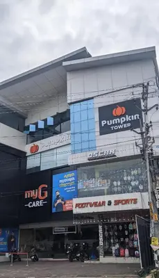 a store front of a building with signs on it at Pumpkin Tower in Malappuram