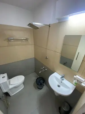 a bathroom with a sink and a toilet and a mirror at Pumpkin Tower in Malappuram