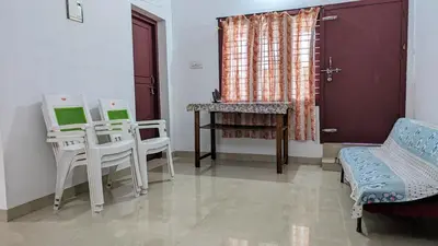 a room with two chairs and a table and a window at Spacious 2-storey home-4 bedroom in Kunnamkulam