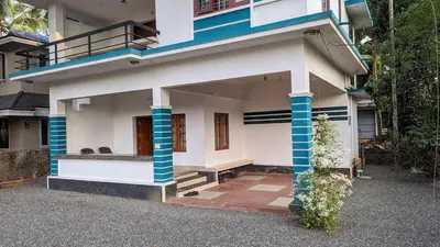a house with blue and white columns on it at Spacious 2-storey home-4 bedroom in Kunnamkulam