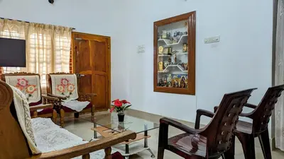 a living room with a table and chairs at Spacious 2-storey home-4 bedroom in Kunnamkulam