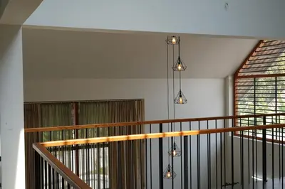 a chandelier hanging from a staircase in a house at Verdant Courtyard, 3BHK, Near IIM, NITC in Kozhikode