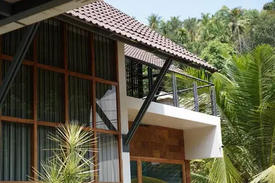 a building with a balcony on the side of it at Verdant Courtyard, 3BHK, Near IIM, NITC in Kozhikode