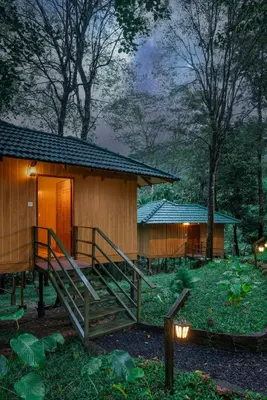a small wooden cabin with a staircase leading to it at De Spicewoods, AC Cabin, Pool, Couple only in Kalpetta